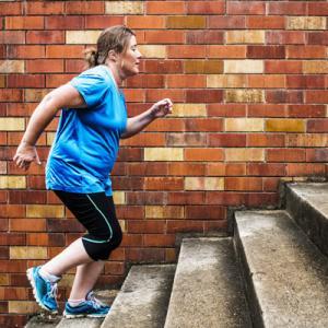 woman doing HIIT exercise on steps outdoors