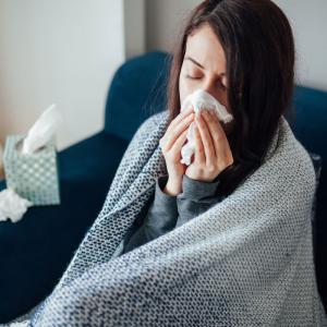 Sick-woman-blowing-her-nose